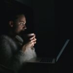 אישה מול המחשב הנייד בחושך